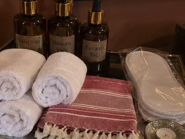 Masaj yağları, rulo havlular, kırmızı çizgili peştemal ve terlik — Karaağaç, Masaj Salonun
